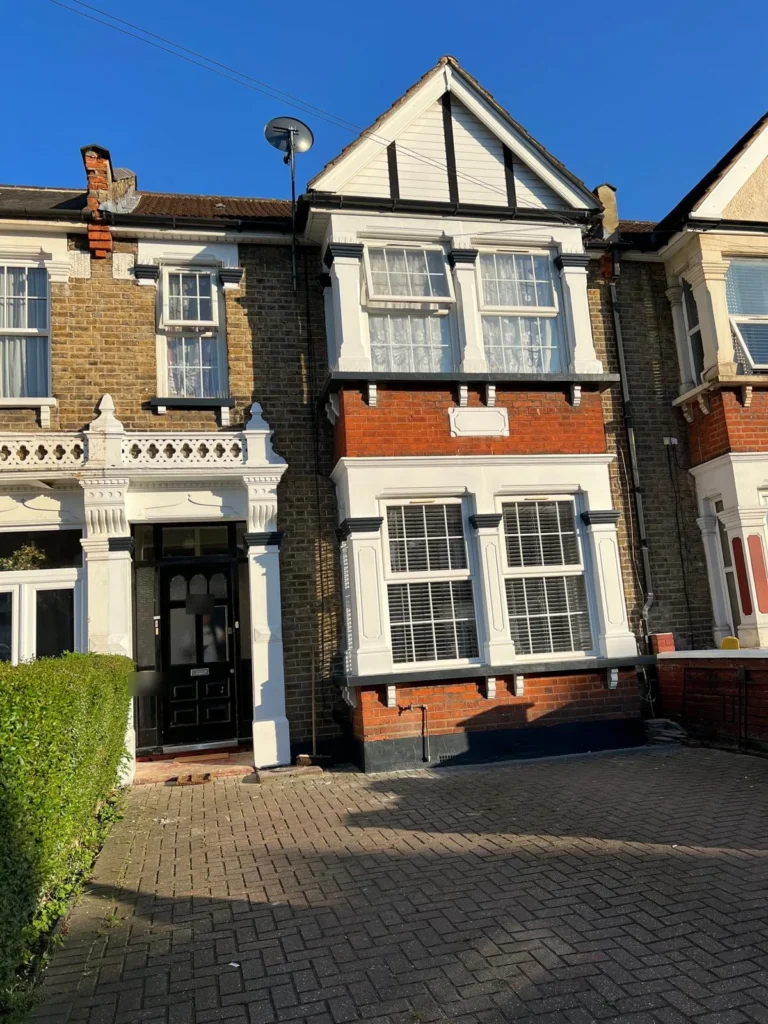 Victorian terrace front elevation with repainted render, bay window and porch