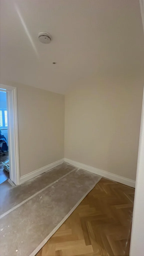 Herringbone parquet flooring leading through a hallway to a doorway