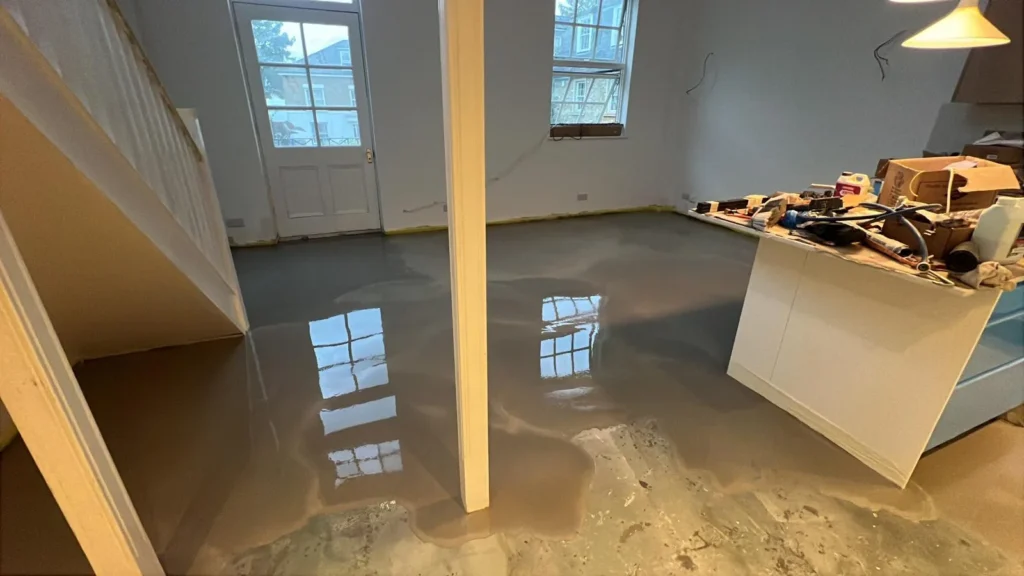 Self-levelling screed freshly poured across a ground floor
