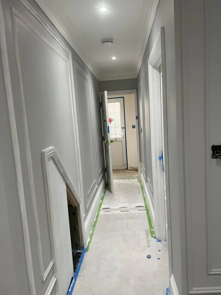 White panelled hallway with pilasters and moulded architraves